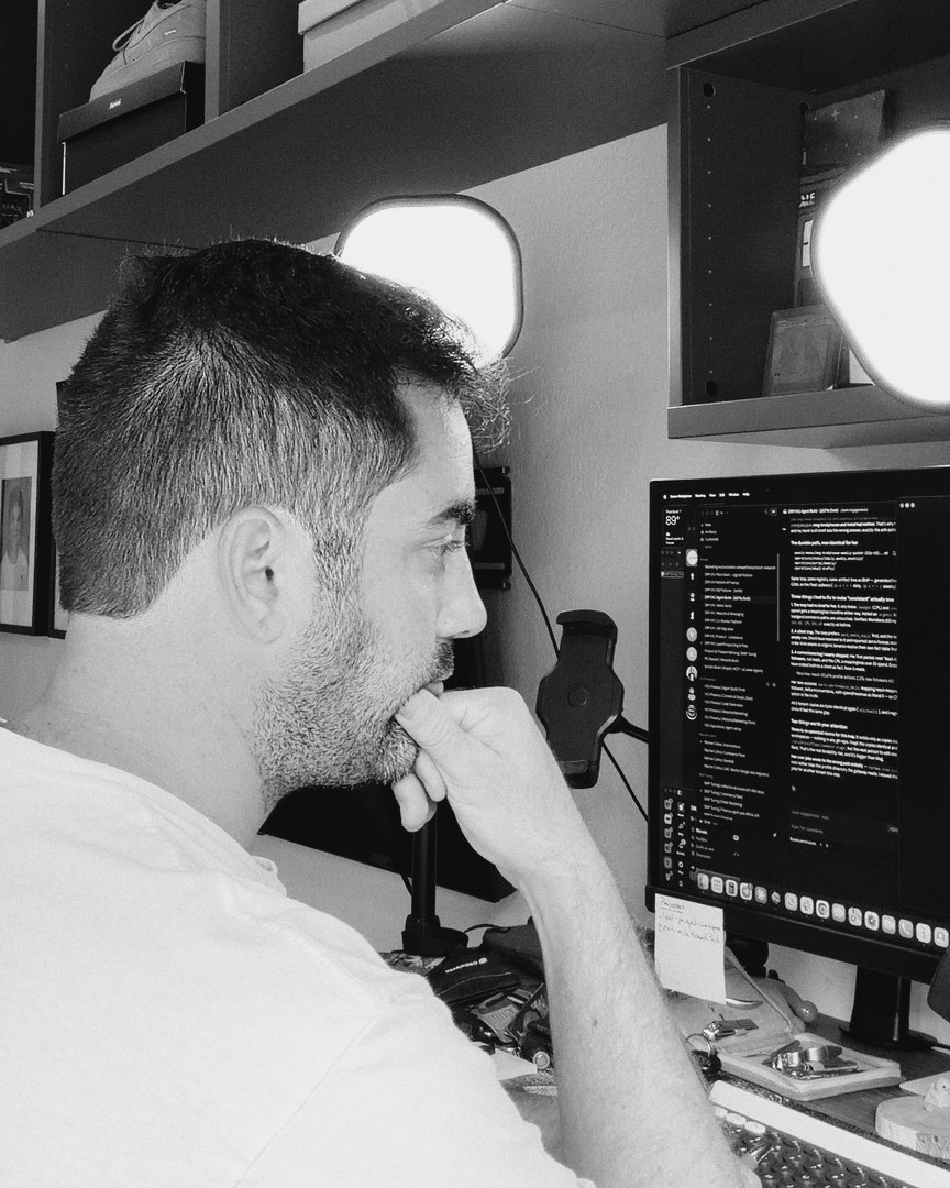 Brian Stewart at his desk, hand on his chin, reading his monitor