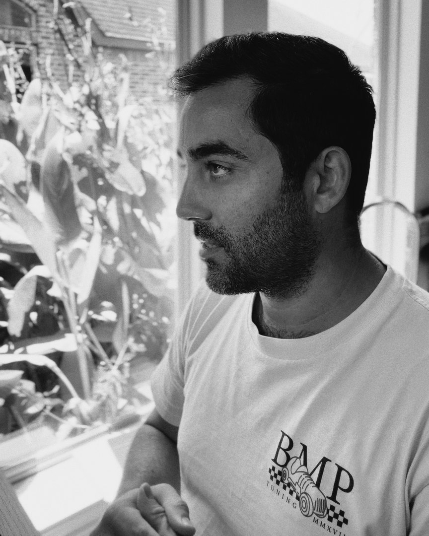 Brian Stewart by a window, mid-sentence, in a BMP Tuning T-shirt